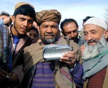 Un grupo de habitantes de Kabul, reunido hoy para escuchar un radio casette.