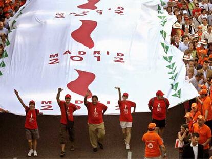 Miles de personas han desplegado la bandera olímpica, la más grande del mundo, en el centro de Madrid.