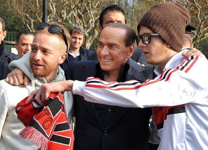 Berlusconi, con dos aficionados en un entrenamiento del Milan el viernes pasado. 