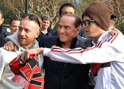 Berlusconi, con dos aficionados en un entrenamiento del Milan el viernes pasado.