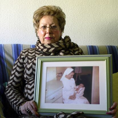 Dolores Chumillas muestra una foto de su hija en brazos de una monja tras dar a luz en 1978.