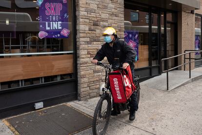 A delivery man bikes with a food bag from Grubhub on April 21, 2021, in New York. Uber Eats, DoorDash and Grubhub sued New York City on Thursday, July 6, 2023, to block its new minimum pay rules for food delivery workers.