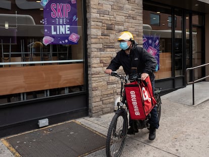 A delivery man bikes with a food bag from Grubhub on April 21, 2021, in New York. Uber Eats, DoorDash and Grubhub sued New York City on Thursday, July 6, 2023, to block its new minimum pay rules for food delivery workers.