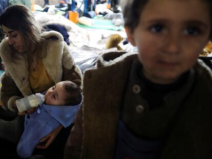 Rifa, mujer kurda de 25 años, alimenta a su bebé de ocho meses con biberón junto a su otra hija, Orvan, de tres años en Bruzgi en la frontera entre Polonia y Bielorrusia, el 25 de noviembre de 2021. Las tres son solicitantes de asilo.