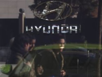 Girls are reflected in the window of a Hyundai car dealership in Madrid