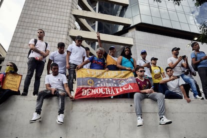 Manifestantes sostienen una bandera que dice "Venezuela libre democrática”.