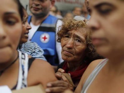 Venezuelanos esperam para receber água filtrada e medicamentos distribuídos pela Cruz Vermelha em Caracas. 