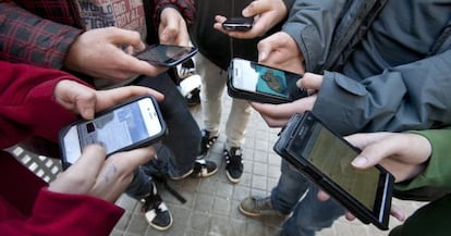 Varios menores se conectan a las redes sociales a través de sus teléfonos móviles.