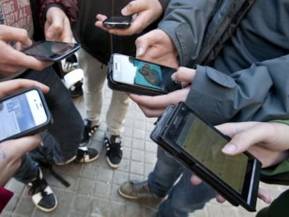 Varios menores se conectan a las redes sociales a través de sus teléfonos móviles.