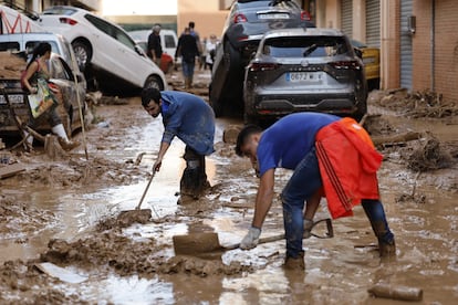 Afectados y voluntarios retirando barro en la localidad de Paiporta.