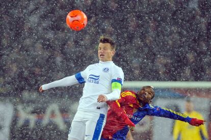 El croata Nikola Kalinic del Dnipro trtata de atrapa el balón ante el jugador del Basilea Adilson Cabral.