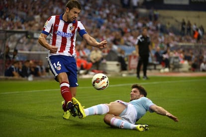 Carles Planas, defensa el Celta, disputa desde el suelo un bal&oacute;n con Gabi, centrocampista del Atl&eacute;tico.