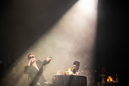 El músico, cantando desde una de las mesas situadas en el escenario.
