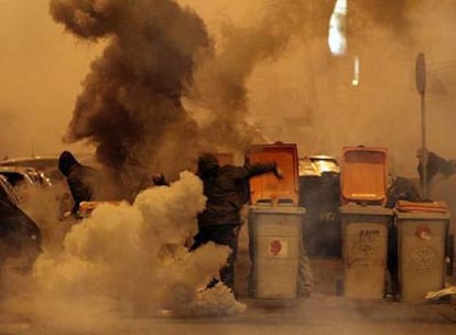 Unos manifestantes con las capuchas puestas queman contenedores en una de las calles de Lavapiés durante los incidentes de ayer.