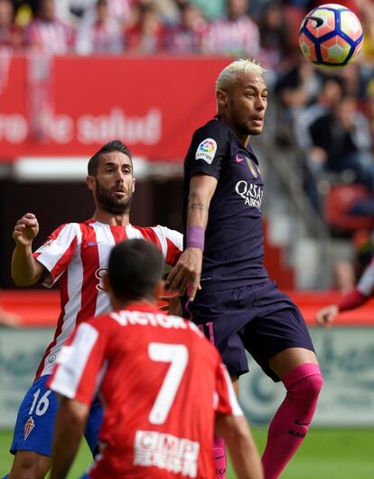 Neymar (d) del FC Barcelona, antes de golpear el balón de cabeza.