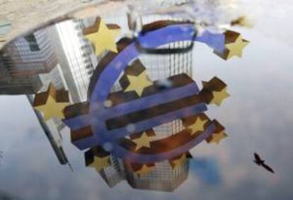 Reflejo en un charco del símbolo del euro frente a la sede del Banco Central Europeo en Fráncfort (Alemania). EFE/Archivo