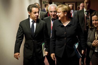 Nicolas Sarkozy y Angela Merkel se dirigen a la cena de trabajo de la sesión inaugural de la cumbre, en Bruselas.