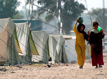 Dos refugiadas paquistaníes transportan agua en un campamento de la zona tribal de Bayaur, cerca de Peshawar.