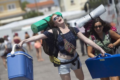 Dos jóvenes expresan su satisfacción al llegar al Camping Arenal para asistir al festival de música Arenal Sound, en Burriana, Castellón.