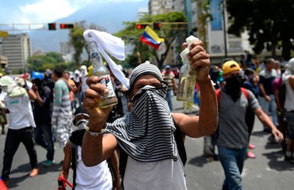 Un manifestante contra el líder chavista muestra dos cócteles molotov mientras participa en una marcha.
