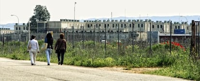 Tres mujeres caminan junto a los exteriores de la cárcel de Alcala-Meco.