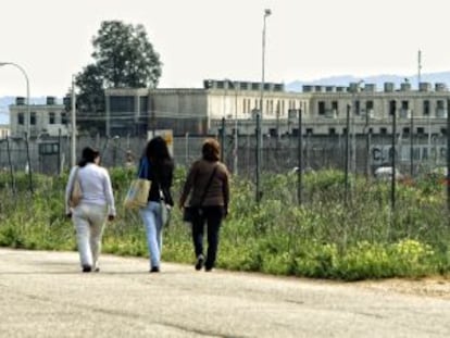 Tres mujeres caminan junto a los exteriores de la cárcel de Alcala-Meco.