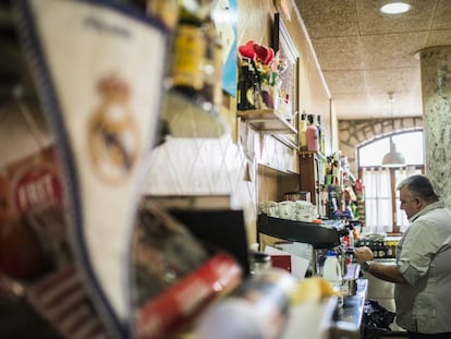 El banderín del Real Madrid en la barra del Casal d'Alfés, el único restaurante del pueblo. En el fondo, su encargado, Gregorio Pifarre uno de los tres madridistas de los 300 habitantes prepara un café para sus clientes.