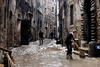 Una mujer trabaja para despejar el camino en la localidad de Cantiano, en la región central italiana de Las Marcas, después de las lluvias torrenciales de la madrugada.