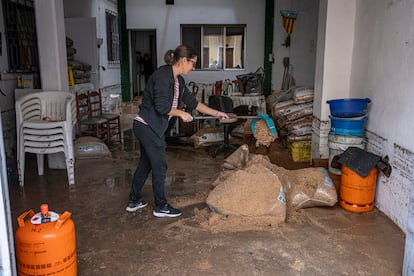 Los vecinos trabajan en la limpieza de sus bajos anegados, este martes en Valencia.