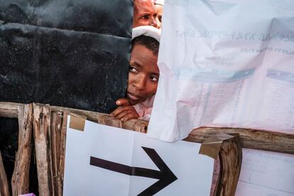 Una mujer mira a través de una pared en el interior de un colegio electoral en el pueblo de Wereb Michael, una zona rural a 15 kilómetros de Bahir Dar, Etiopía. Los ciudadanos votan en unas elecciones nacionales retrasadas que se celebran con el telón de fondo de la guerra y la hambruna en la región septentrional de Tigray y con dudas sobre la credibilidad de los comicios.