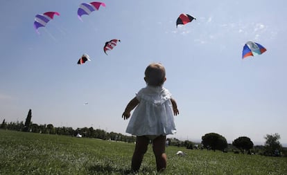 Una niña ve volar cometas sobre el Parque Juan Carlos I.