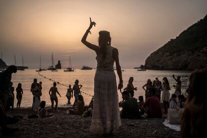 Una mujer baila al atardecer en la cala Benirrás de Ibiza.