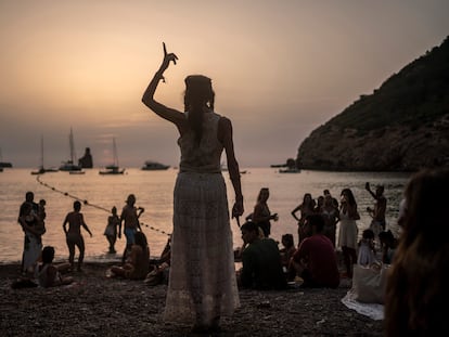 Una mujer baila al atardecer en la cala Benirrás de Ibiza.
