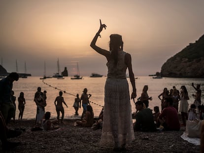 Una mujer baila al atardecer en la cala Benirrás de Ibiza.