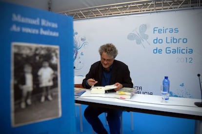 Manuel Rivas firmando un ejemplar de su libro