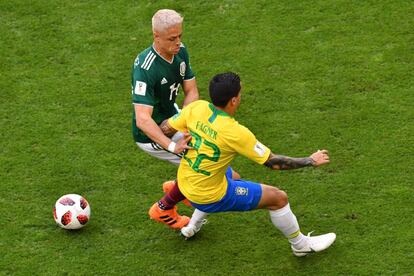 Javier Hernández , do México, e o zagueiro brasileiro Fagner lutam pela bola.