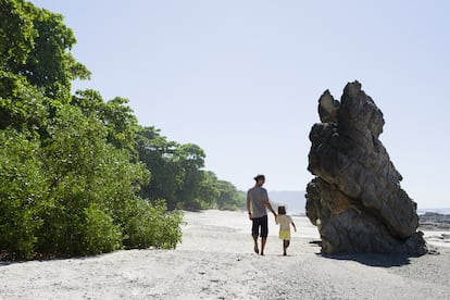 Un padre y su hija caminan por la playa de Santa teresa en Costa Rica. 
