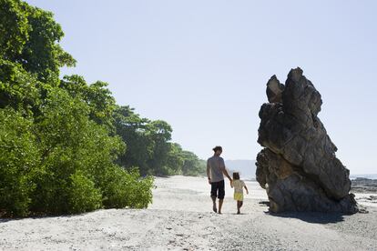 Un padre y su hija caminan por la playa de Santa teresa en Costa Rica.