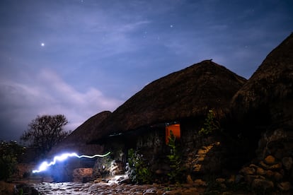 Una persona camina durante la noche iluminando con una linterna, en una foto de larga exposión, en Nabusimake.