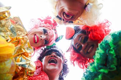 Participantes del desfile posan para una fotografía mientras celebran.