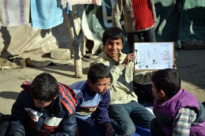 Bachar se concentra en su pintura mientras otros compañeros muestran su creación. Según Usama Ayoub, de Zakira, los tanques y banderas son una de las constantes en los dibujos de niños refugiados.