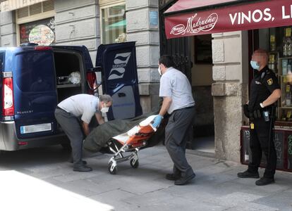 Dos trabajadores de una funeraria  recogen los cuerpos del hostal Levante.