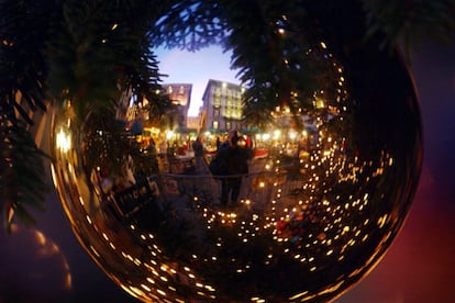 La Piazza della Riforma de Lugano (Suiza) es el epicentro de estas fiestas en la ciudad. Un tradicional mercadillo copa la plaza, que vemos en esta foto reflejado en una bola de un gran rbol de Navidad.