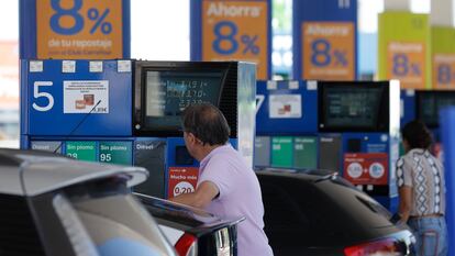 Dos personas repostan en una gasolinera de Madrid.