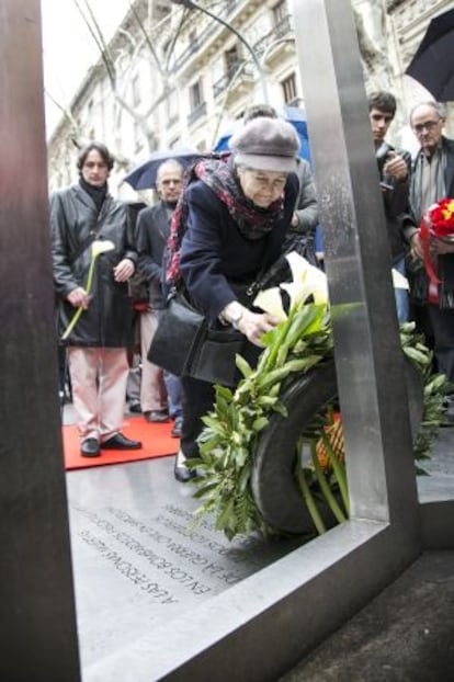 Una superviviente deja una corona sobre el monumento a las víctimas de los bombardeos.