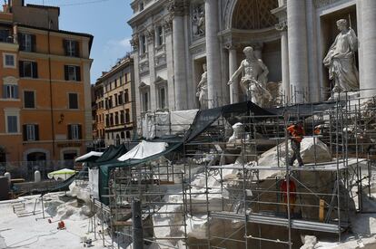 En la imagen, un grupo de trabajadores llevan a cabo obras de restauración de la Fontana de Trevi, el 24 de julio de 2015. A pesar de que durante las trabajos la fuente ha permanecido drenada, ha existido una pequeña cuenca de agua para que los visitantes pudieran seguir la tradición de arrojar una moneda de espalda al monumento, una costumbre que trae buena suerte, según los romanos.