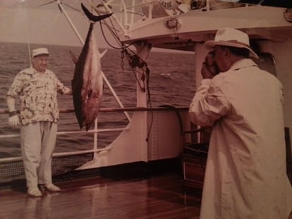 El dictador Francisco Franco toma una fotograf&iacute;a a Andr&eacute;s Zala y al bonito que han pescado a bordo del Azor.