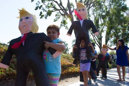 Hijas de inmigrantes y activistas protestan con piñatas con la figura de Donald Trump.