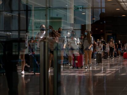 Varios pasajeros llegan al aeropuerto del Prat de Barcelona, este lunes.