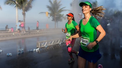 Dos corredoras cruzan el paseo marítimo de Ipanema durante el medio maratón de Río de Janeiro.